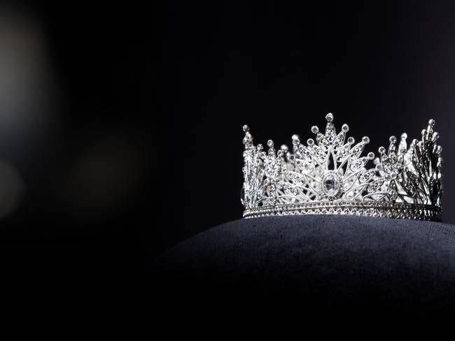 Diamond Silver Crown for Miss Pageant Beauty Contest, Crystal Tiara jewelry decorated gems stone and abstract dark background on black velvet fabric cloth, Macro photography copy space for text logo Cortesía Jade