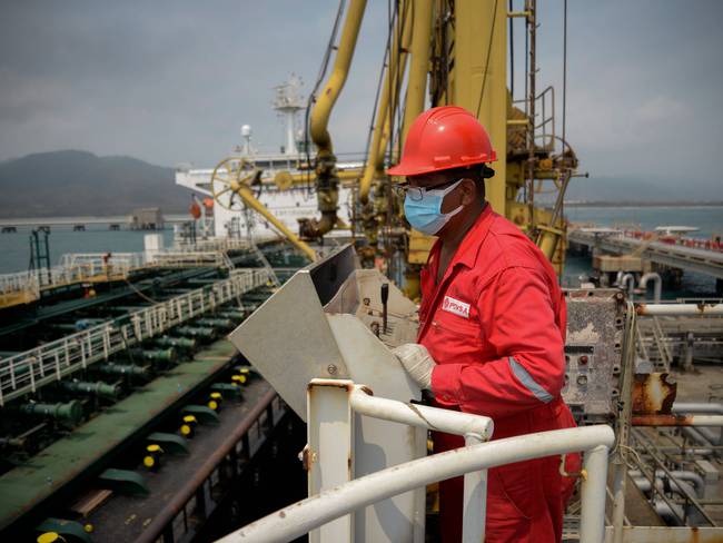 A worker of the Venezuelan state oil company PDVSA looks at the Iranian-flagged oil tanker Fortune as it docks at the El Palito refinery in Puerto Cabello in the northern state of Carabobo, Venezuela, on May 25, 2020. - The first of five Iranian tankers carrying much-needed gasoline and oil derivatives docked in Venezuela on Monday, Caracas announced amid concern in Washington over the burgeoning relationship between countries it sees as international pariahs. (Photo by - / AFP) (Photo by -/AFP via Getty Images)