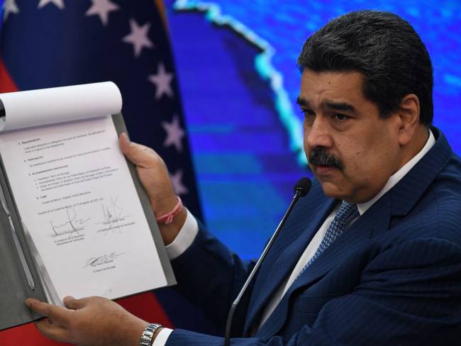 Nicolas Maduro muestra documento firmados por representantes del Gobierno venezolano y la oposición durante negociaciones en México.