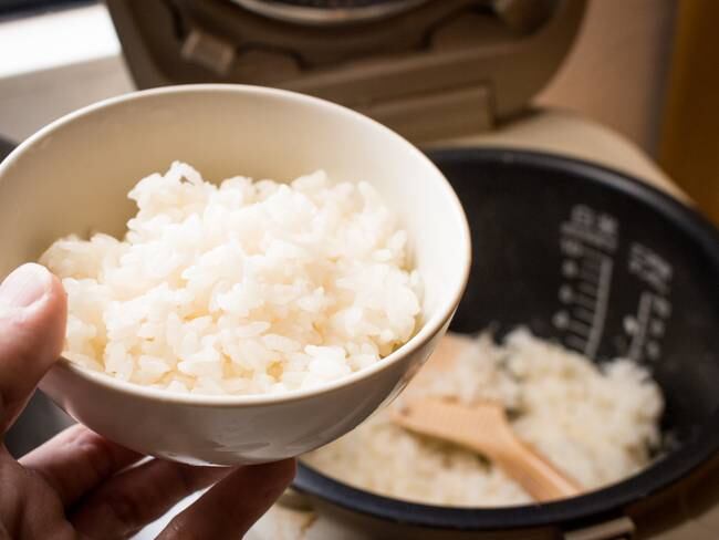Persona sosteniendo un recipiente con arroz luego de hacerlo en una olla arrocera / Foto: GettyImages