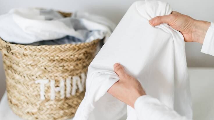Persona revisando sábanas blancas (Foto vía Getty Images)