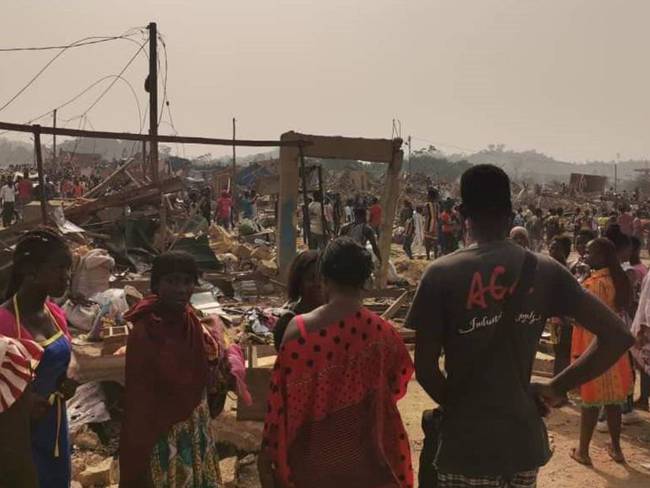 Ciudadanos ghaneses en medio de la zona donde explotó un camión que transportaba explosivos.