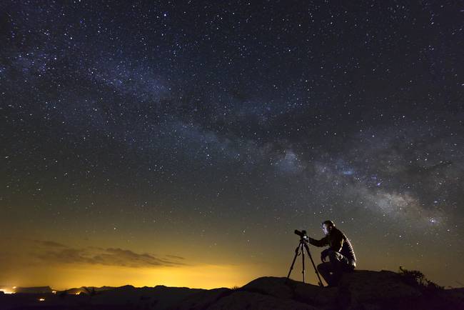 Hombre tomándole fotos el cielo con su cámara (Getty Images)