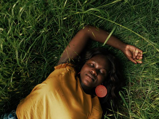Mujer recostada en el pasto durmiendo (Getty Images)
