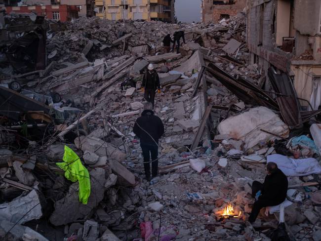 La gente pasa junto a montones de escombros el 15 de febrero de 2023 en Hatay, Turquía. Foto de Burak Kara/Getty Images.