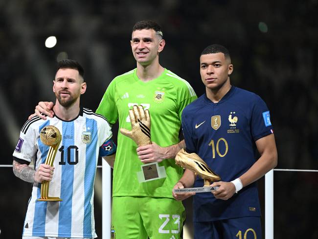 Lionel Messi, Emiliano Martinez y Kylian Mbappé en la ceremonia de premiación. (Photo by Lionel Hahn/Getty Images)