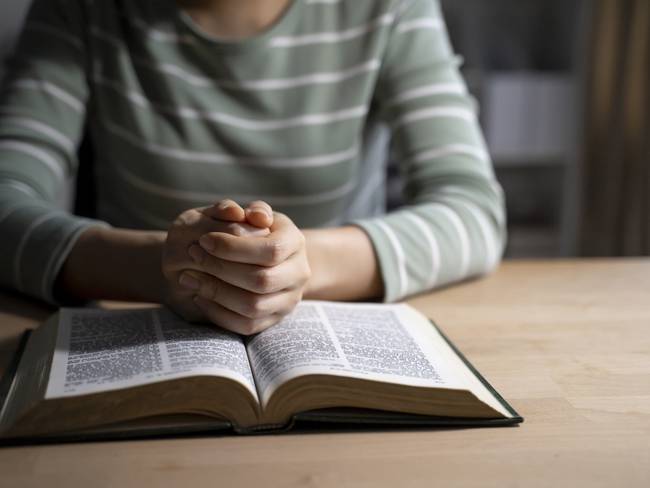 Mujer leyendo la Biblia en la mesa (Foto vía Getty Images)