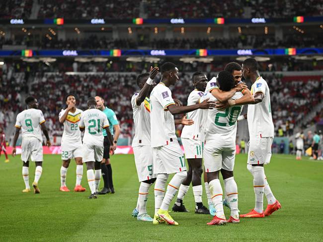 DOHA, QATAR - NOVEMBER 25: Bamba Dieng of Senegal celebrates with teammates after scoring their team&#039;s third goal during the FIFA World Cup Qatar 2022 Group A match between Qatar and Senegal at Al Thumama Stadium on November 25, 2022 in Doha, Qatar. (Photo by Stuart Franklin/Getty Images)