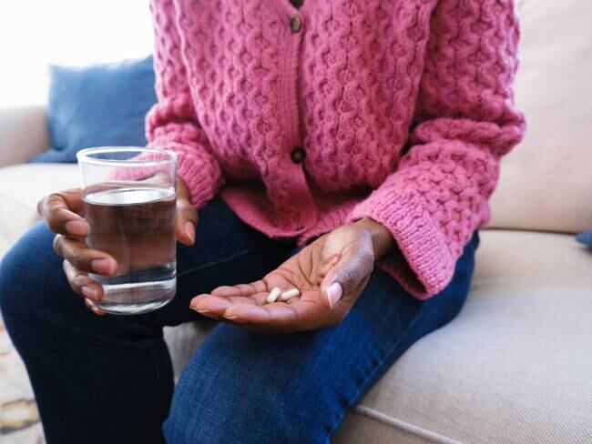 Persona tomando una pastilla con agua. Imagen de referencia. Foto. Getty Images.