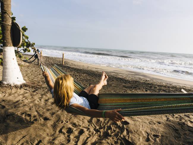 Mujer disfruta del sol y el mar en hamaca en la costa caribeña de Colombia (Getty Images)