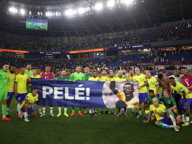 DOHA, QATAR - DECEMBER 05: Brazil players hold a banner showing support for former Brazil player Pele after the FIFA World Cup Qatar 2022 Round of 16 match between Brazil and South Korea at Stadium 974 on December 05, 2022 in Doha, Qatar. (Photo by Hector Vivas - FIFA/FIFA via Getty Images)