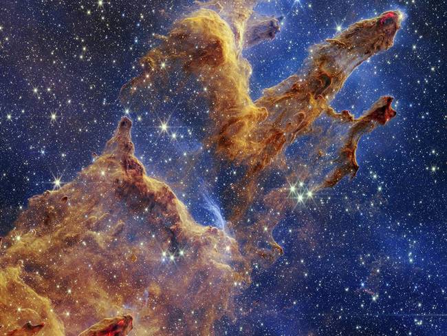 Los Pilares de la Creación se destacan en un caleidoscopio de color en la vista de luz infrarroja cercana del Telescopio Espacial James Webb de la NASA. - Foto: NASA, ESA, CSA, STSCI;/EUROPA PRESS