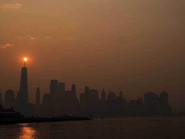 El sol sale detrás del One World Trade Center, mientras que el humo de los incendios forestales de Canadá cubre el distrito de Manhattan el 8 de junio de 2023 en Nueva Jersey. (Foto de Eduardo Muñoz Álvarez/Getty Images)