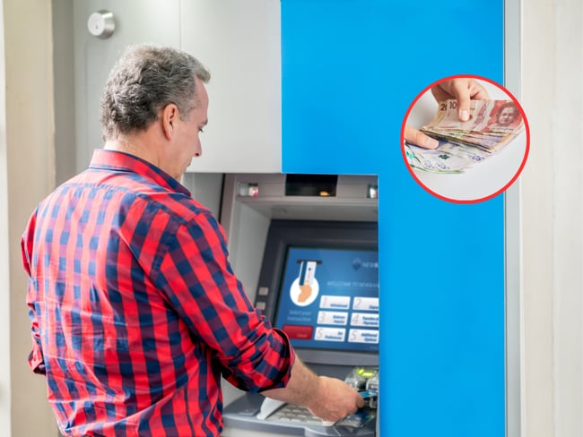 Persona retirando dinero de un cajero automático y de fondo dinero colombiano (Fotos vía Getty Images