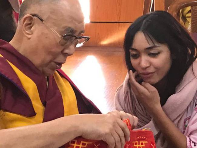 Tania regala al Dalai Lama una mochila de su región.