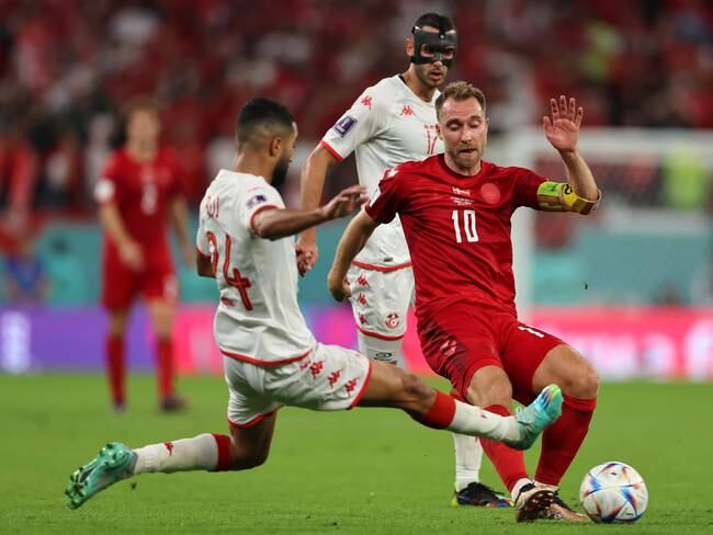 AL RAYYAN, QATAR - NOVEMBER 22: Ali Abdi of Tunisia challenges Christian Eriksen of Denmark as he plays the ball during the FIFA World Cup Qatar 2022 Group D match between Denmark and Tunisia at Education City Stadium on November 22, 2022 in Al Rayyan, Qatar. (Photo by Youssef Loulidi/Fantasista/Getty Images)