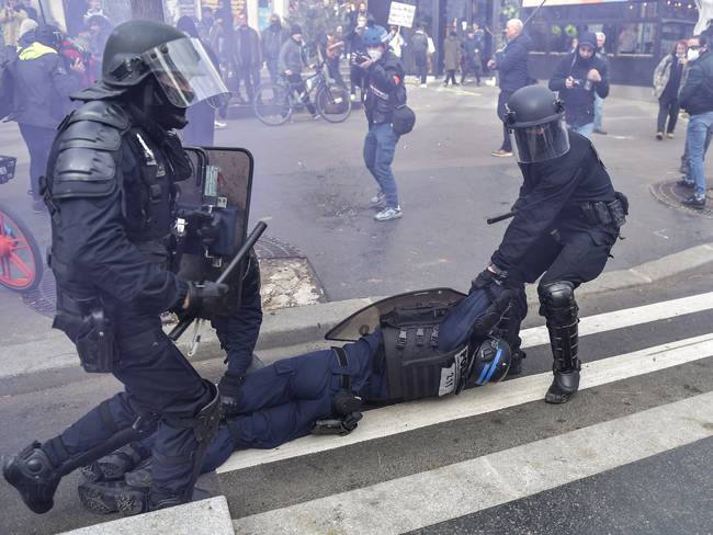 Policías antidisturbios intentan llevar un uniformado desmallado en medio de las protestas sociales en Francia. 
(Foto: Firas Abdullah/Anadolu Agency via Getty Images)