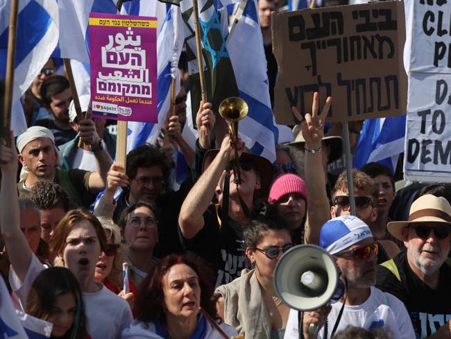 27 March 2023, Israel, Jerusalem: Demonstrators hold Israeli flags during a protest in Jerusalem as part of a national wide strike against Juridical reform of the Israeli right wing government. Photo: Ilia Yefimovich/dpa (Photo by Ilia Yefimovich/picture alliance via Getty Images)