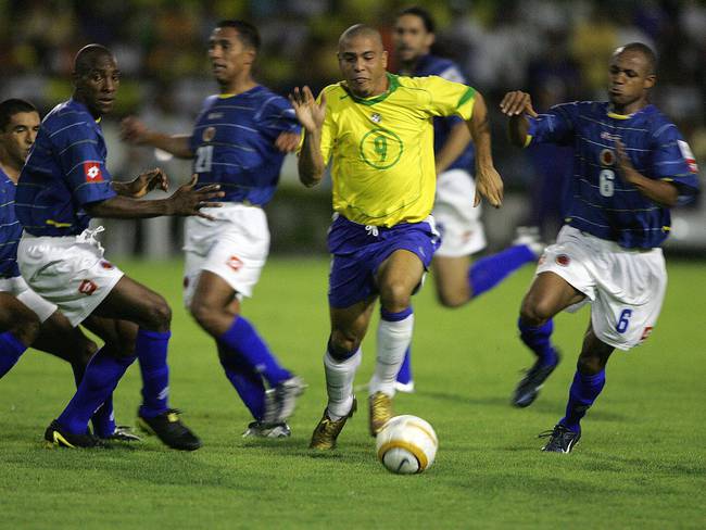Ronaldo elude jugadores colombianos durante un partido disputado en octubre del 2004.  (Photo credit should read ORLANDO KISSNER/AFP via Getty Images)
