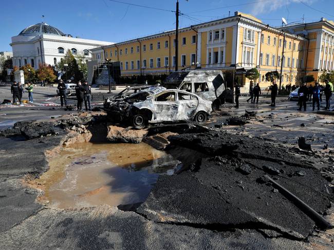 Expertos policiales examinan autos destruidos en el centro de la capital ucraniana de Kyiv después de varios ataques rusos el 10 de octubre de 2022 / AFP