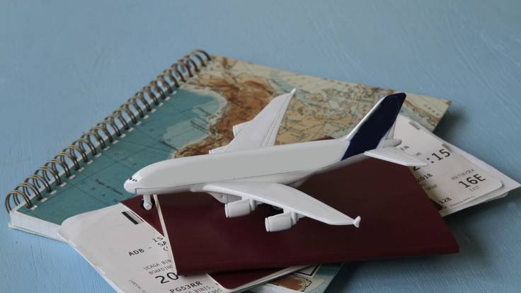 En la imagen se ve un pasaporte, tarjetas de embarque, un mapa y un avión / Foto: GettyImages