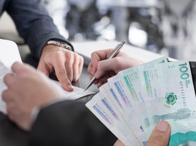 Imágenes de referencia de contrato y dinero. Fotos: Getty Images