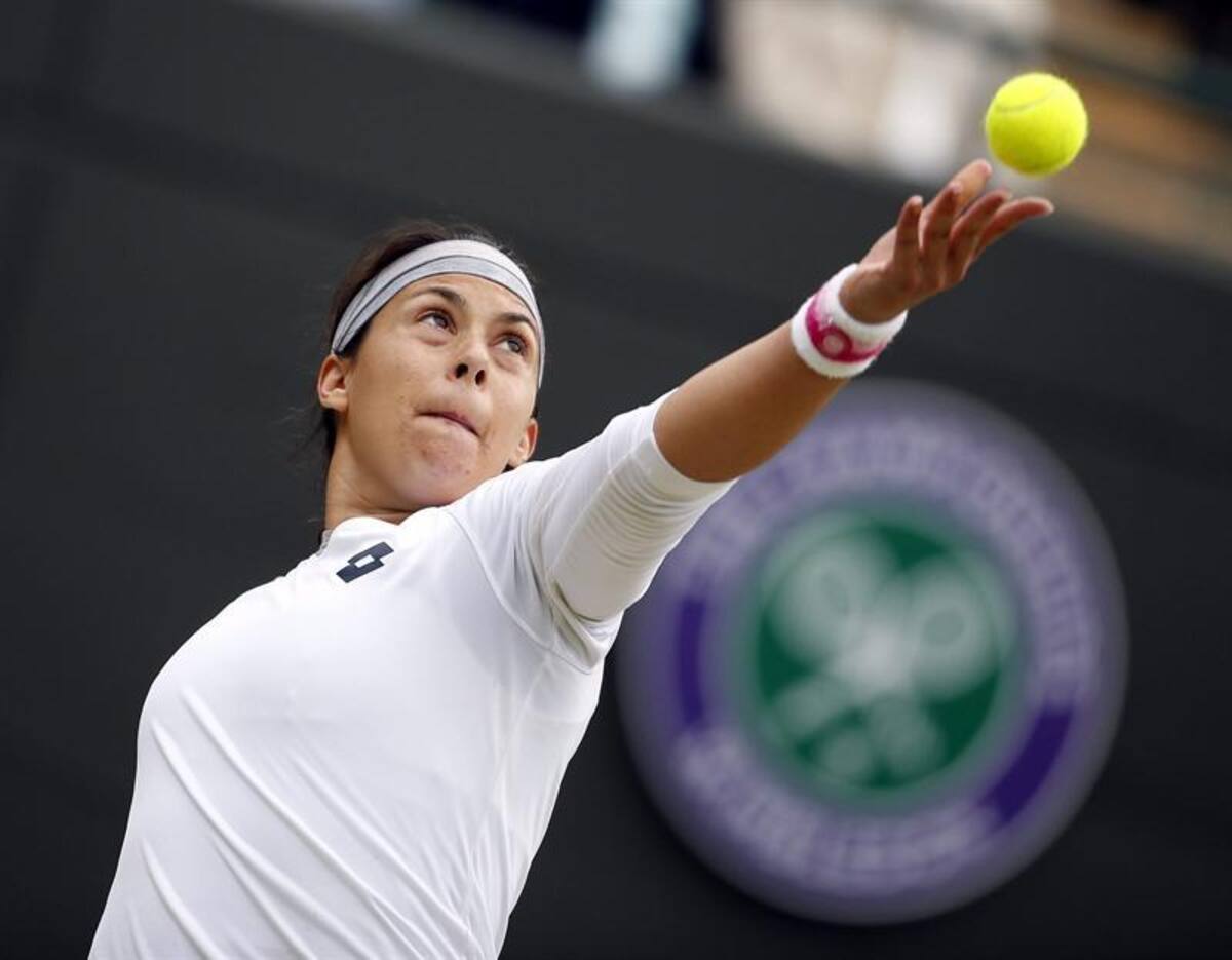 La tenista francesa Marion Bartoli sirve una bola a la estadounidense Sloane Stephens, durante el partido de cuartos de final del torneo de tenis de Wimbledon.