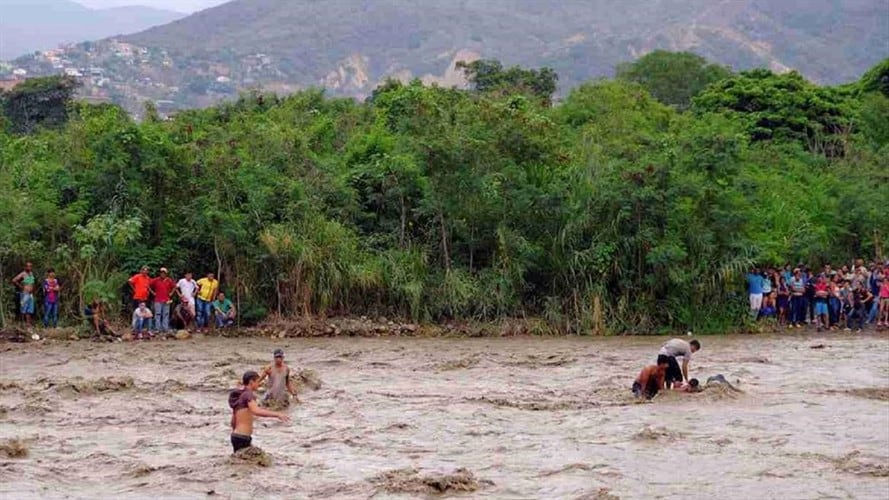 En improvisadas canoas extranjeros intentan cruzar a Colombia por el río Táchira. Foto: Reuters