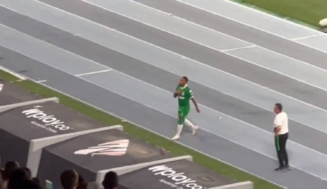 Jarlan Barrera muestra el escudo de Nacional a los hinchas del Junior en el estadio Metropolitano.