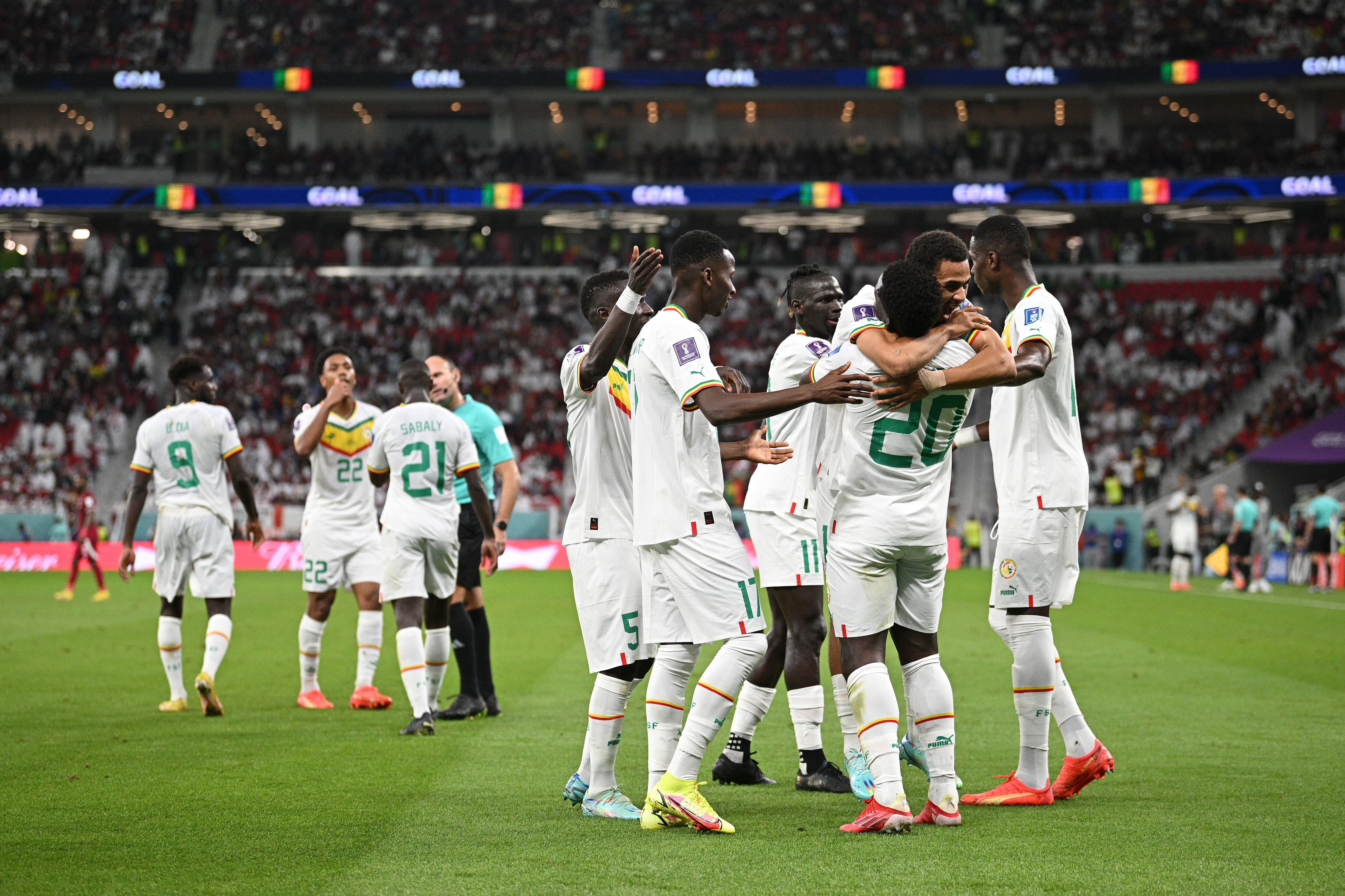 DOHA, QATAR - NOVEMBER 25: Bamba Dieng of Senegal celebrates with teammates after scoring their team's third goal during the FIFA World Cup Qatar 2022 Group A match between Qatar and Senegal at Al Thumama Stadium on November 25, 2022 in Doha, Qatar. (Photo by Stuart Franklin/Getty Images)