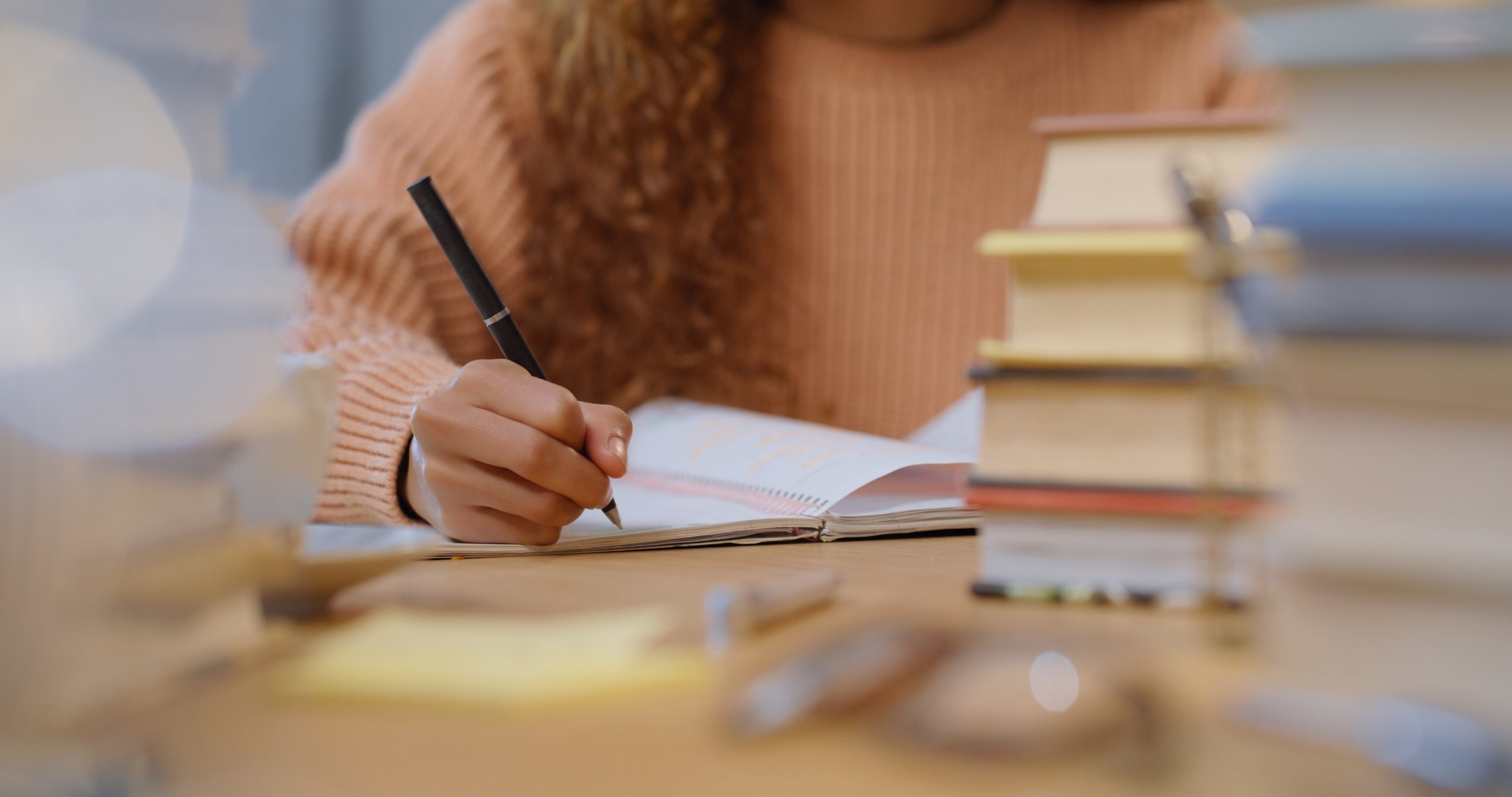 Woman student study, writing and reading education book for an exam or test at school, college or university. Academic girl studying and learning for knowledge while at a table with notes on paper