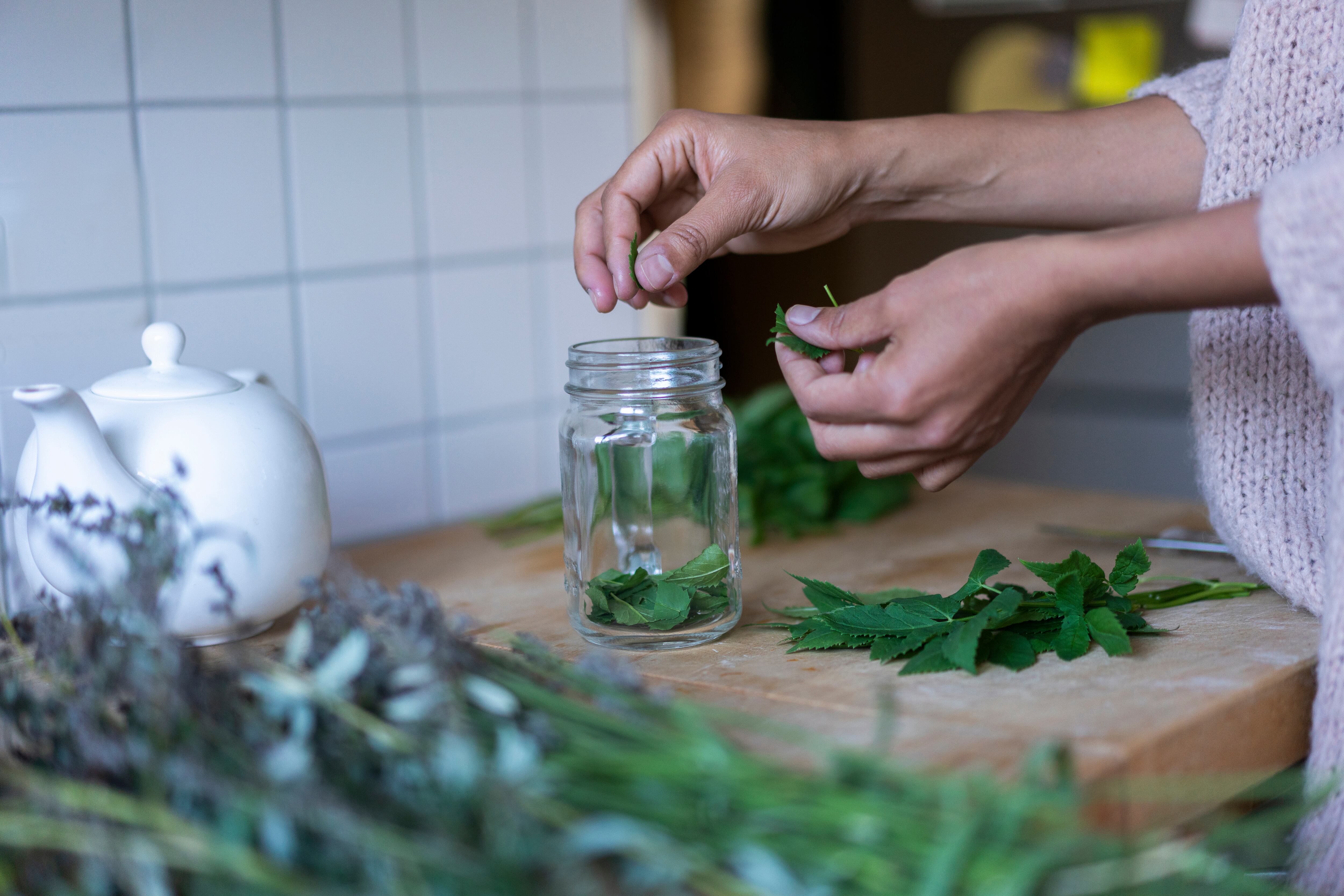 Mujer utilizando hierbas para preparar una bebida (Foto vía Getty Images)
