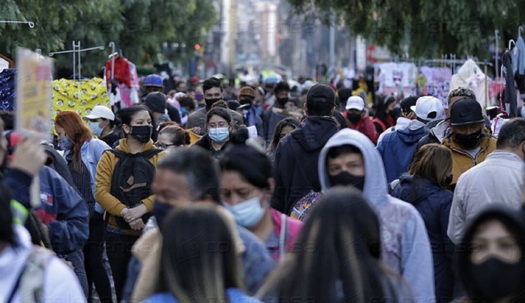 Población caminando por las calles sin distanciamiento social