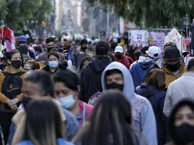 Población caminando por las calles sin distanciamiento social