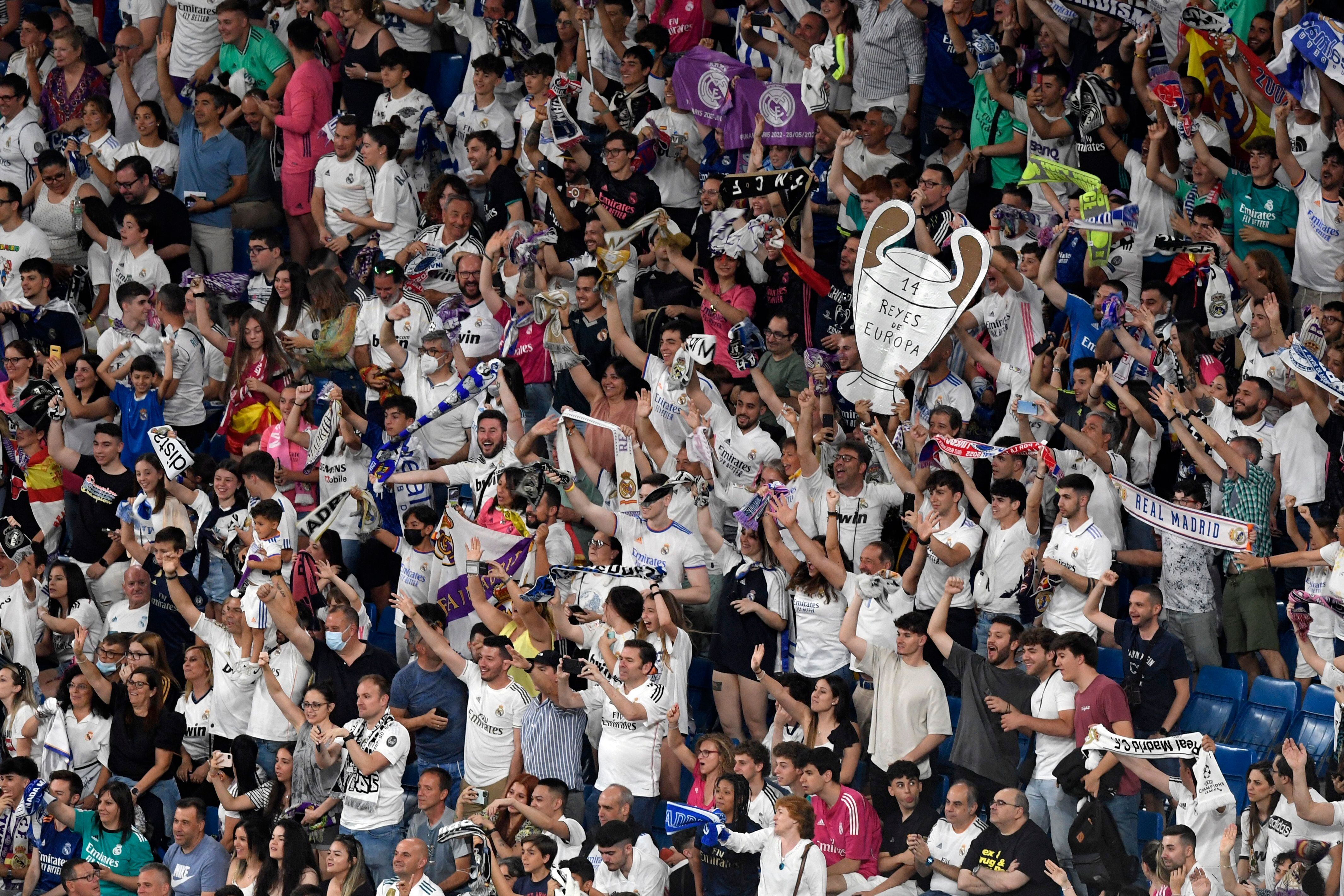Real Madrid fans celebrate their team's 14th European Cup on May 29, 2022, at the Santiago Bernabeu stadium in Madrid, a day after beating Liverpool in the UEFA Champions League final in Paris. - Real Madrid claimed a 14th European Cup as Vinicius Junior's goal saw them beat Liverpool 1-0 in the Champions League final at the Stade de France amid chaotic scenes yesterday. (Photo by OSCAR DEL POZO / AFP) (Photo by OSCAR DEL POZO/AFP via Getty Images)