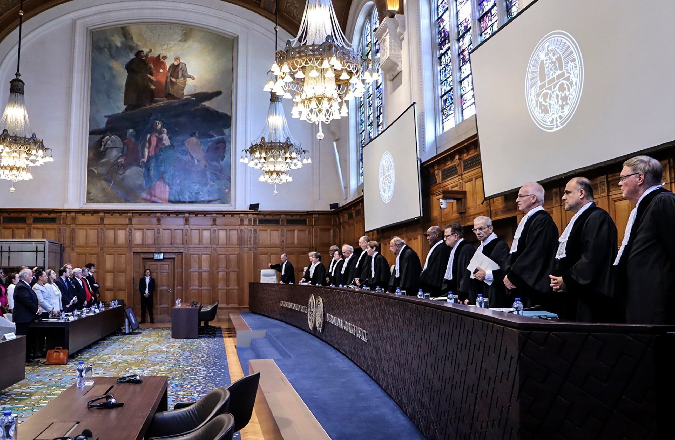 Representantes de Nicaragua y Colombia (L) y jueces de la Corte Internacional de Justicia (CIJ) de pie durante la última batalla legal entre Colombia y Nicaragua por un petróleo y pescado- rica franja del Mar Caribe, en La Haya / AFP