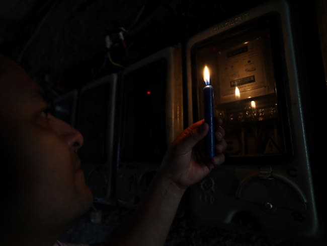 Un ciudadano ecuatoriano revisa un medidor de luz en Quito (Ecuador). 
 EFE/ José Jácome