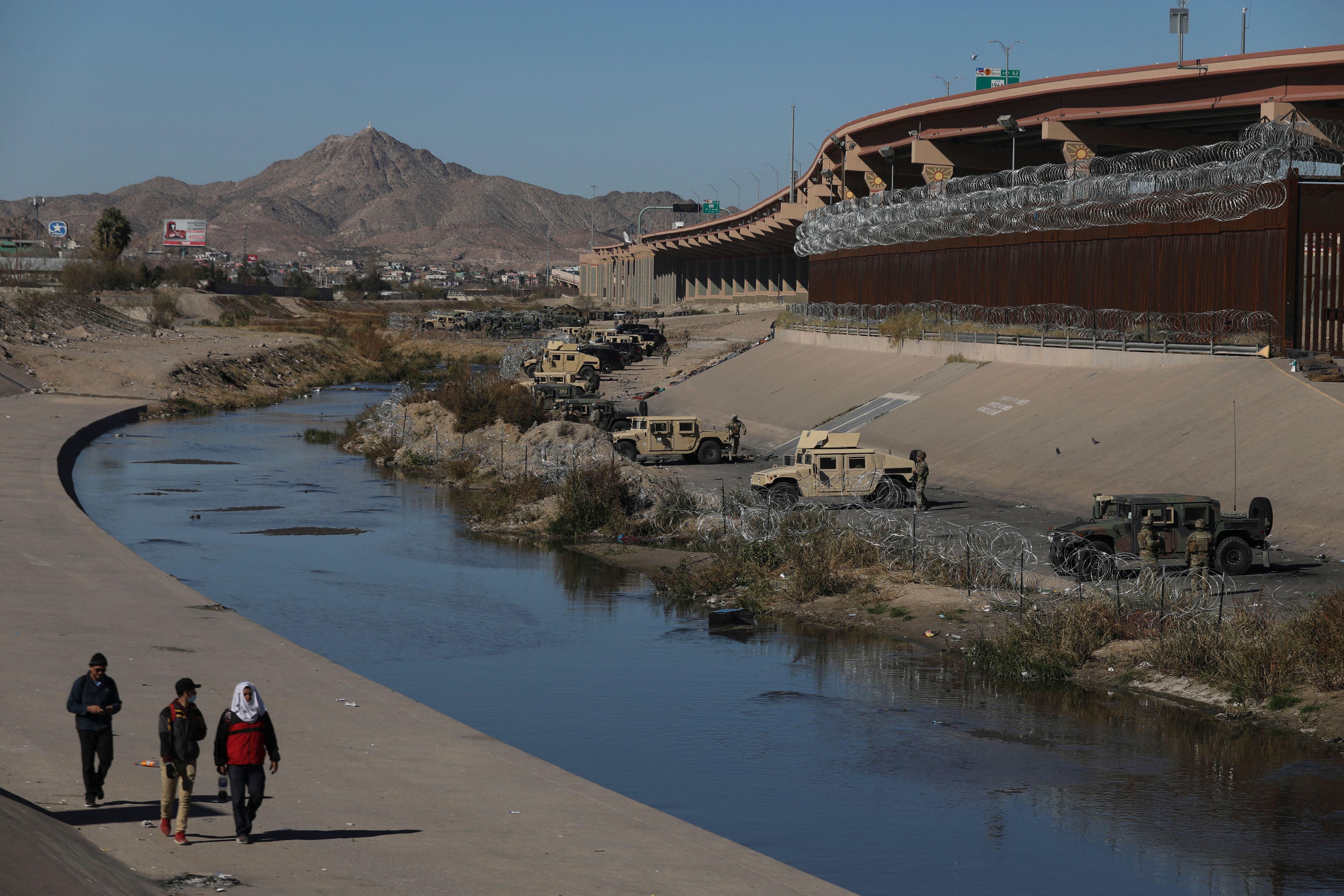 Texas National Guard agents guard the banks of the Rio Bravo river (or Rio Grande river, as it is called in the US) in El Paso, Texas, US, on the border with Ciudad Juarez, Chihuahua state, Mexico on December 21, 2022. - Title 42, a President Donald Trump pandemic-era law that authorize United States border officials to expel migrants, is supposed to end on December 21. (Photo by Herika Martinez / AFP) (Photo by HERIKA MARTINEZ/AFP via Getty Images)