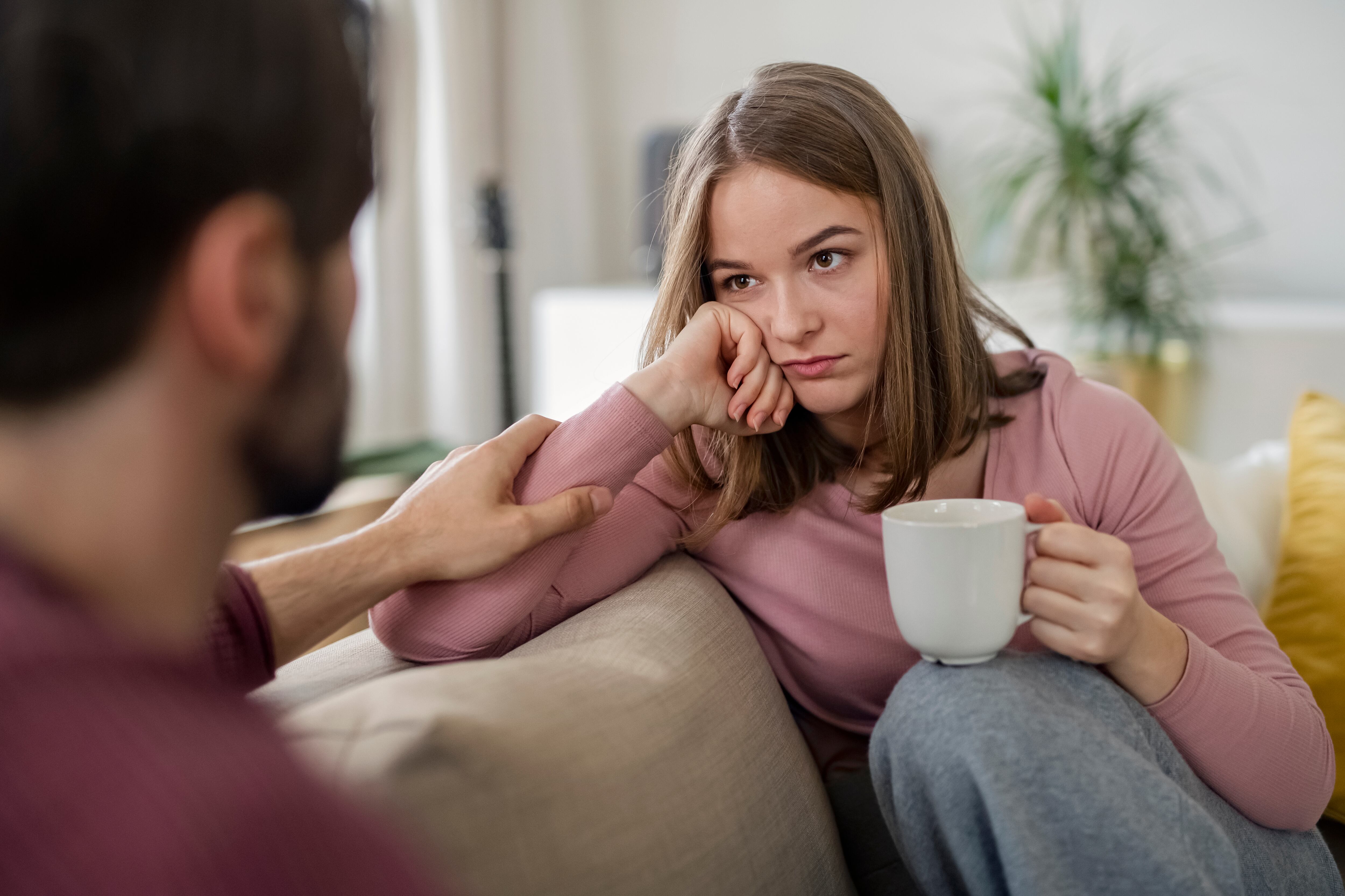 Mujer con una taza, hablando con un hombre. (Foto: Getty Images)