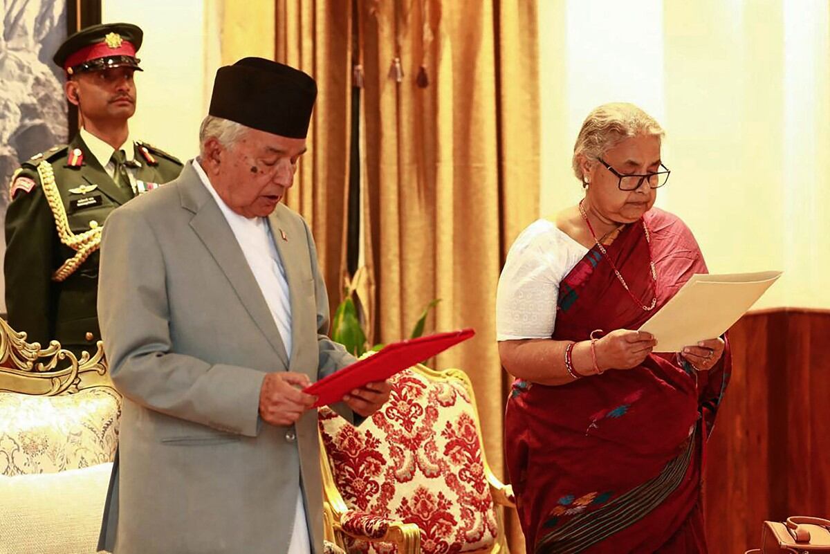 Nepal's President Ram Chandra Paudel (L) administers the oath to the country's newly appointed Prime Minister Sushila Karki during her swearing-in-ceremony at the President House in Kathmandu on September 12, 2025. Nepal's former chief justice Sushila Karki was sworn on September 12 to lead the transition as the country's next prime minister after deadly anti-corruption protests ousted the government. (Photo by Sujan GURUNG / AFP)