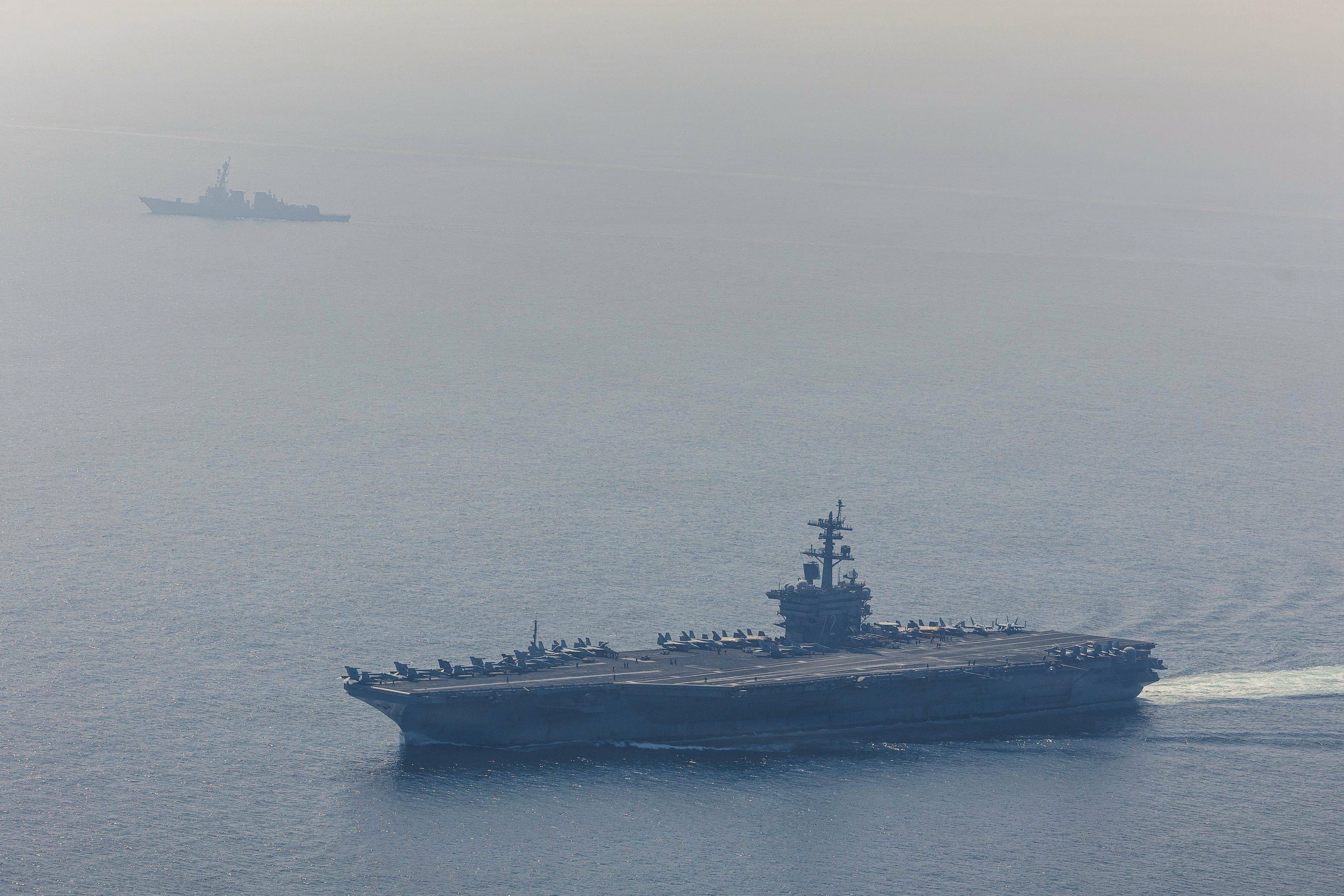 In this handout photograph released by the US Navy on February 6, 2026, Nimitz-class aircraft carrier USS Abraham Lincoln (CVN 72) and Arleigh Burke-class guided-missile destroyer USS Frank E. Petersen Jr. (DDG 121) sail in the Arabian Sea, on February 6. The two foes recently resumed indirect talks, after the US president repeatedly threatened military action against Iran, at first over a deadly crackdown on protesters last month then more recently over its nuclear programme. Iran's atomic energy chief on February 19, 2026, said "no country can deprive Iran of the right" to nuclear enrichment, following fresh US warning that there were "many reasons" to strike the Islamic republic. (Photo by Petty officer 1st Class Jesse Monford / US NAVY / AFP) / RESTRICTED TO EDITORIAL USE - MANDATORY CREDIT "AFP PHOTO / U.S. NAVY/ MASS COMMUNICATION SPECIALIST 1ST CLASS JESSE MONFORD" - HANDOUT - NO MARKETING NO ADVERTISING CAMPAIGNS - DISTRIBUTED AS A SERVICE TO CLIENTS