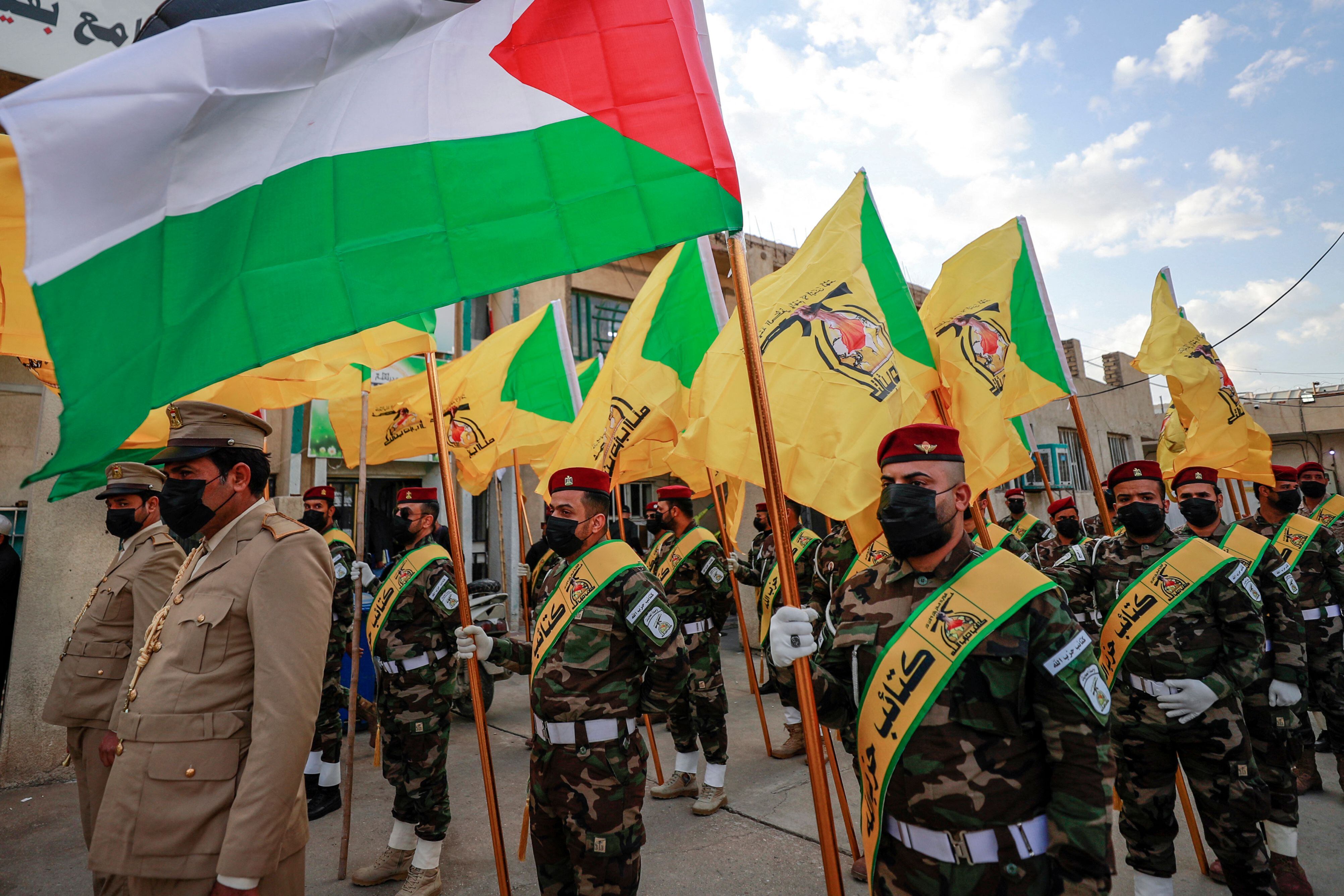 Members of the Hezbollah brigades, Kataeb Hezbollah, attend the funeral of Fadel al-Maksusi, a fighter who was also part of the "Islamic resistance in Iraq", the group that has claimed all recent attacks against US troops in Iraq and Syria, in Baghdad on November 21, 2023. According to security sources, earlier on November 21 a drone strike hit a vehicle belonging to a pro-Iran group in Iraq, killing one of its occupants. (Photo by AHMAD AL-RUBAYE / AFP) (Photo by AHMAD AL-RUBAYE/AFP via Getty Images)