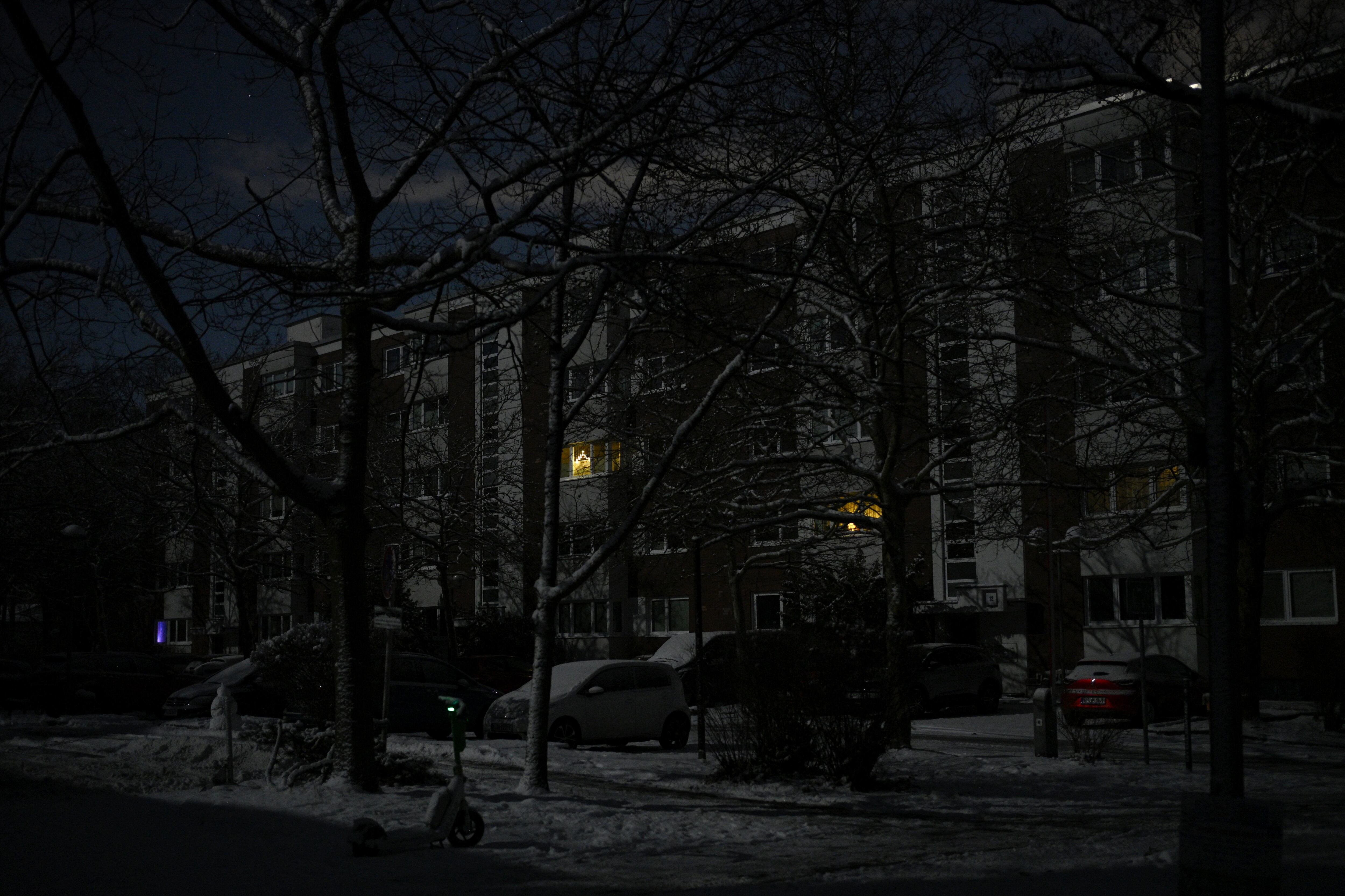 Some battery-operated Christmas decorations are seen in windows of a residential building in the Zehlendorf district in southwest Berlin on early January 4, 2026, after power cables in the area were seriously damaged causing a power outage which left tens of thousands of households in the German capital without electricity. The widespread power outage in southwest Berlin, affecting tens of thousands of households, was deliberately caused with incendiary devices, according to Berlin's Senator for Economic Affairs. It was "clearly" a "deliberate act," Senator Giffey said on January 4. The bridge over the Teltow Canal, where five high-voltage and ten medium-voltage cables were destroyed, had been "rigged with incendiary devices." (Photo by RALF HIRSCHBERGER / AFP)