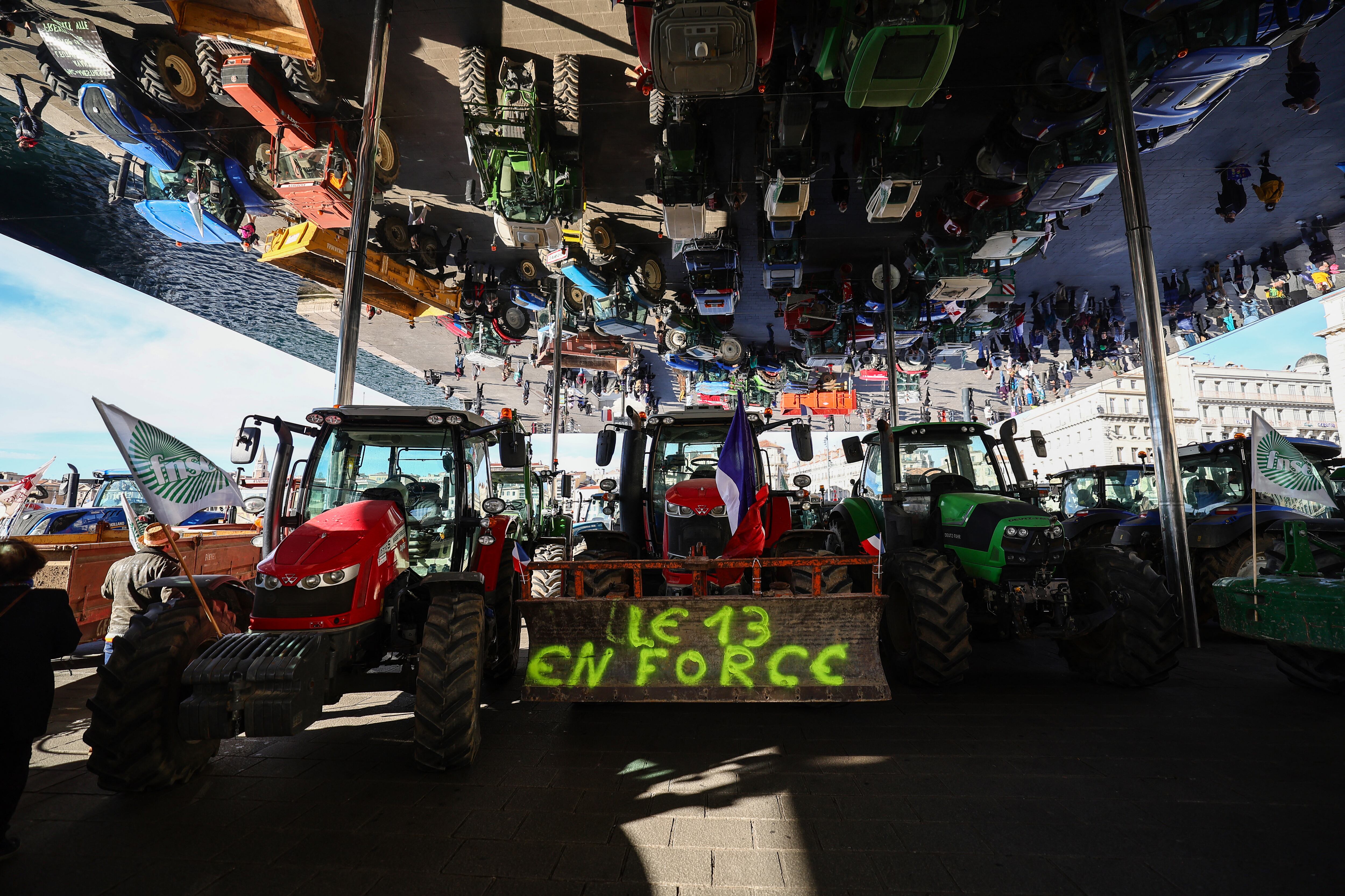 This photograph taken on February 19, 2024, shows parked tractors under the Ombirere at the Vieux Port (Old Port) during a demonstration of French farmers against agricultural policies, in Marseille. Farmers across Europe have staged protests in recent weeks over shrinking incomes, rising costs and what they say are increasingly onerous environmental rules approved by the 27-nation EU. (Photo by CLEMENT MAHOUDEAU / AFP) (Photo by CLEMENT MAHOUDEAU/AFP via Getty Images)