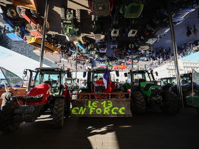 This photograph taken on February 19, 2024, shows parked tractors under the Ombirere at the Vieux Port (Old Port) during a demonstration of French farmers against agricultural policies, in Marseille. Farmers across Europe have staged protests in recent weeks over shrinking incomes, rising costs and what they say are increasingly onerous environmental rules approved by the 27-nation EU. (Photo by CLEMENT MAHOUDEAU / AFP) (Photo by CLEMENT MAHOUDEAU/AFP via Getty Images)