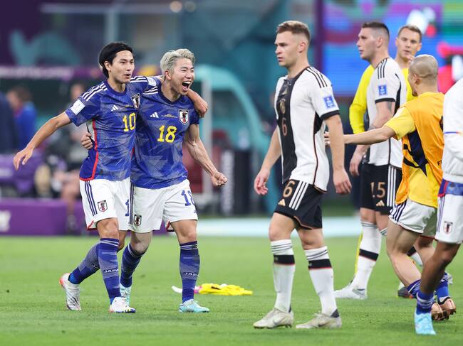 DOHA, QATAR - NOVEMBER 23: Takuma Asano and Takumi Minamino of Japan celebrate on the final whistle during the FIFA World Cup Qatar 2022 Group E match between Germany and Japan at Khalifa International Stadium on November 23, 2022 in Doha, Qatar. (Photo by Alex Livesey - Danehouse/Getty Images)