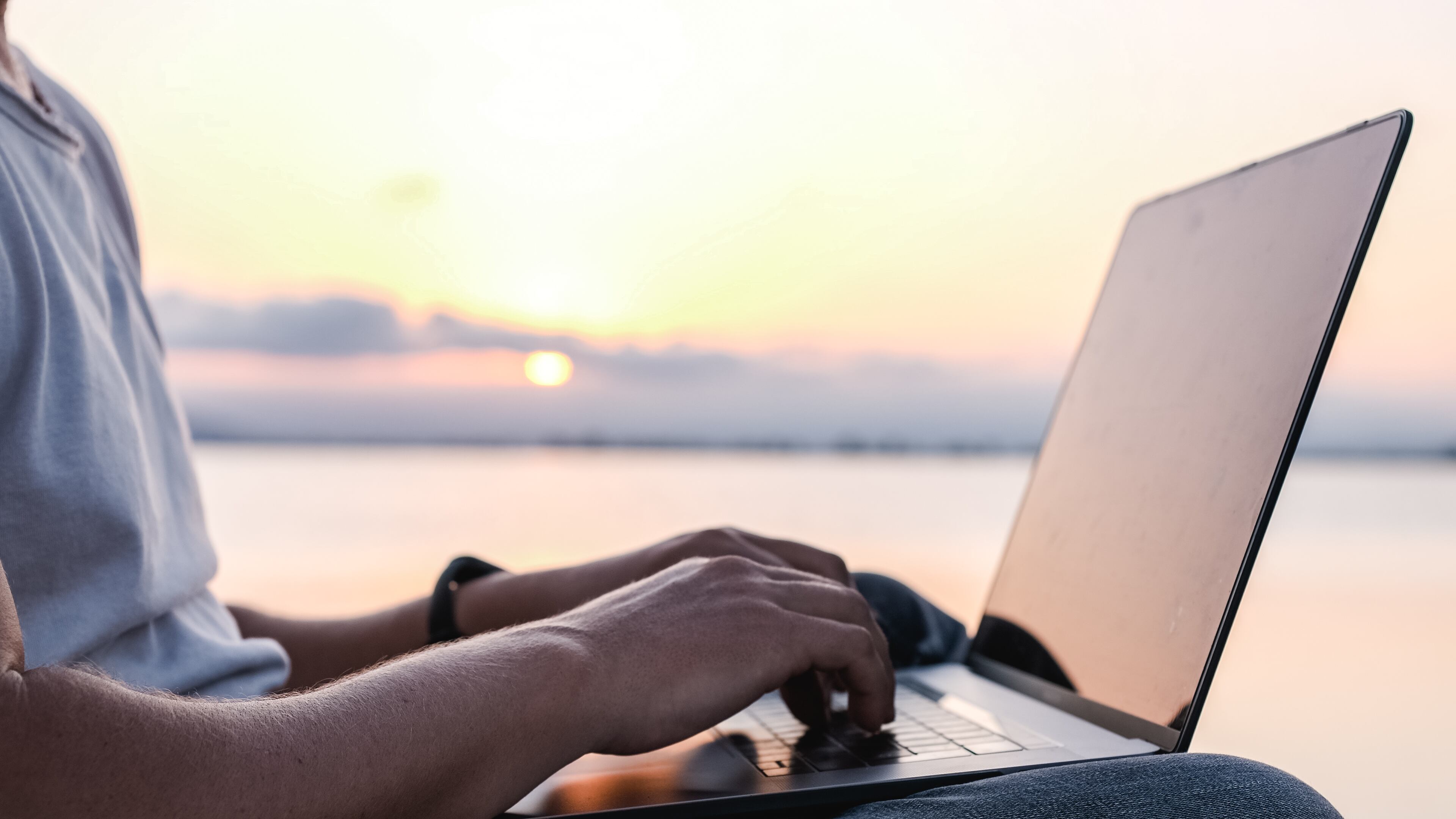 Hombre trabajando en un portátil al atardecer / Foto: GettyImages
