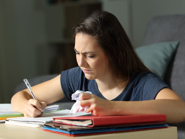 Mujer enojada escribiendo en un cuaderno (Getty Images)