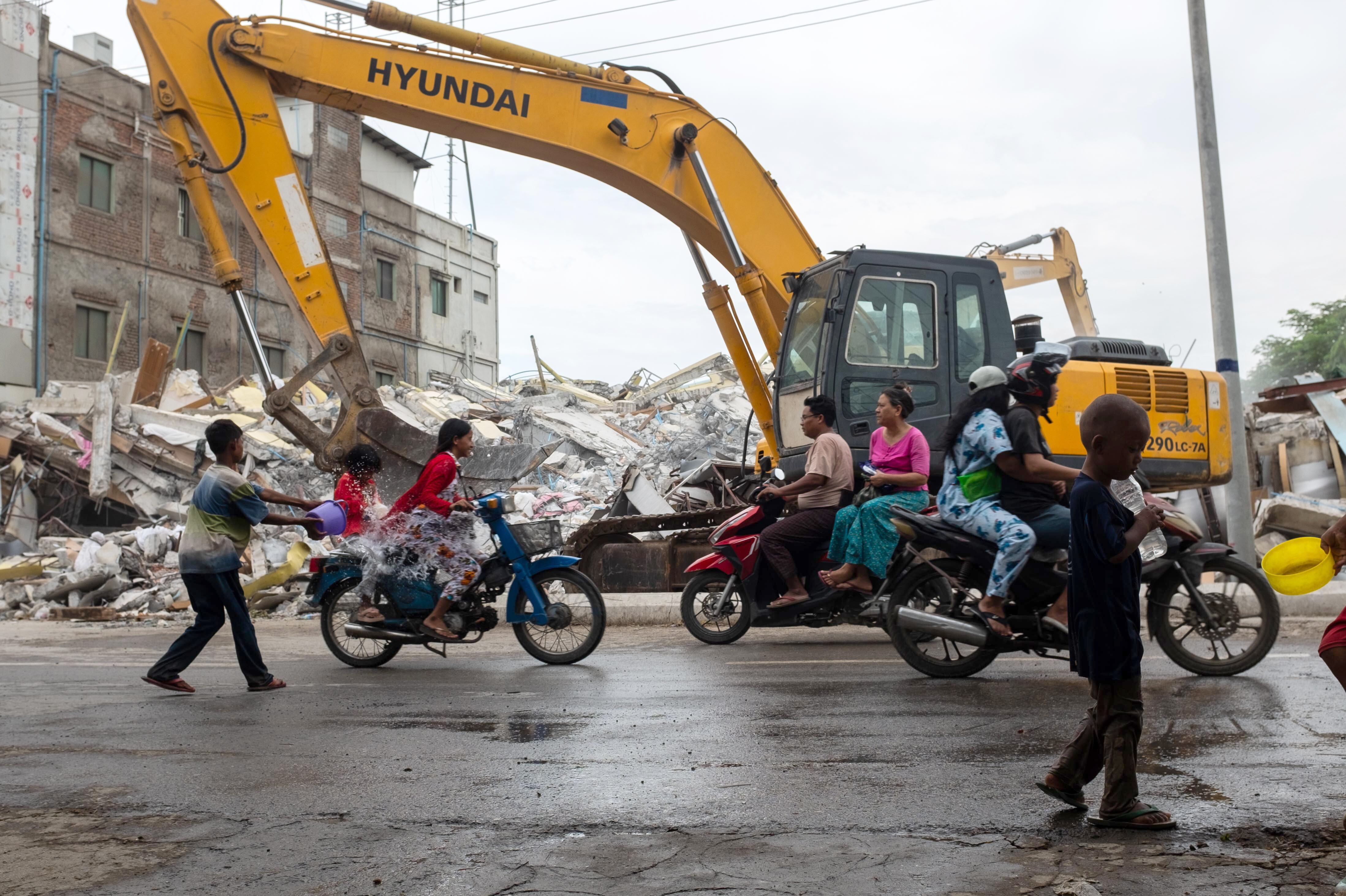 MANDALAY (Myanmar), 14/04/2025.- People splash each other with water in front of a collapsed building during the Thingyan (water festival) in Mandalay, Myanmar, 14 April 2025. The annual water festival, known as Thingyan in Myanmar, sees people gathering to celebrate by splashing water and throwing powder at each other as a symbol of cleansing and washing away the sins from the past year. The festival marks the start of the traditional New Year and is similarly celebrated in countries such as Myanmar, Thailand, Laos, and Cambodia. This year, Myanmar will celebrate the Thingyan (water festival) without music or dance following the powerful earthquake that struck the country on 28 March, according to the Myanmar government. (Terremoto/sismo, Camboya, Birmania, Tailandia) EFE/EPA/STRINGER