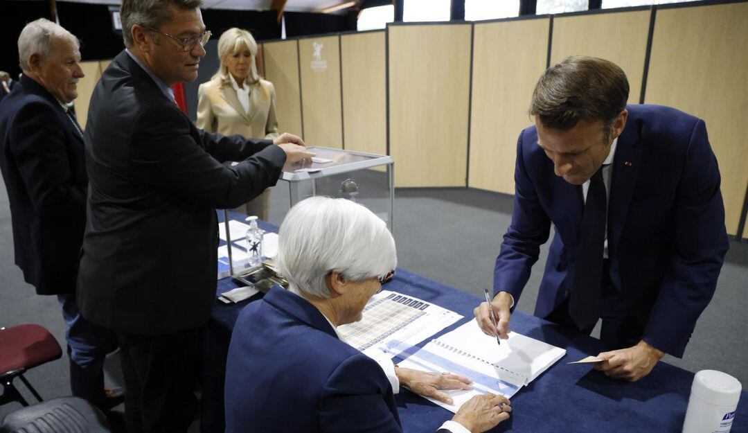 El presidente de Francia, Emmanuel Macron firma después de emitir su voto en las elecciones parlamentarias francesas en un colegio electoral en Le Touquet, en el norte de Francia